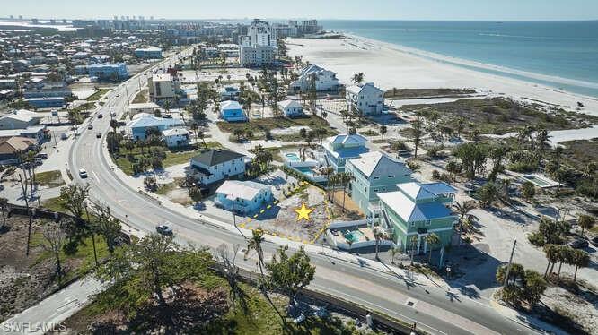 Birds eye view of property with a water view and a view of the beach