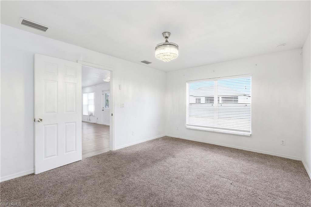 Carpeted spare room featuring baseboards