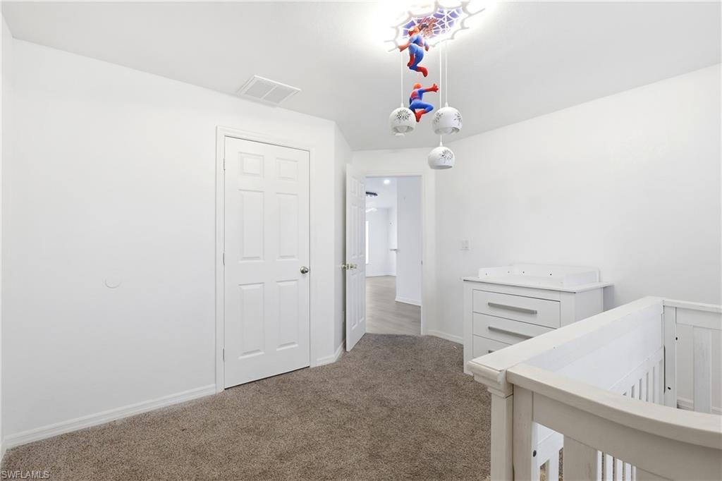 Hallway with carpet flooring and baseboards