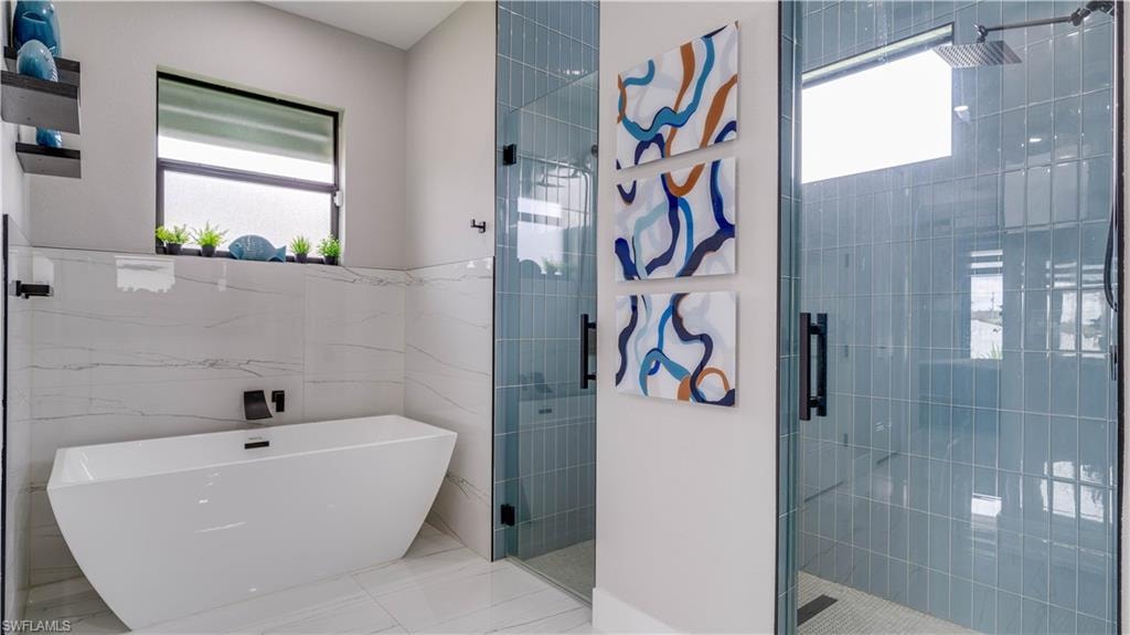 Primary bathroom with a soaking tub, and a walk through shower with dual shower systems