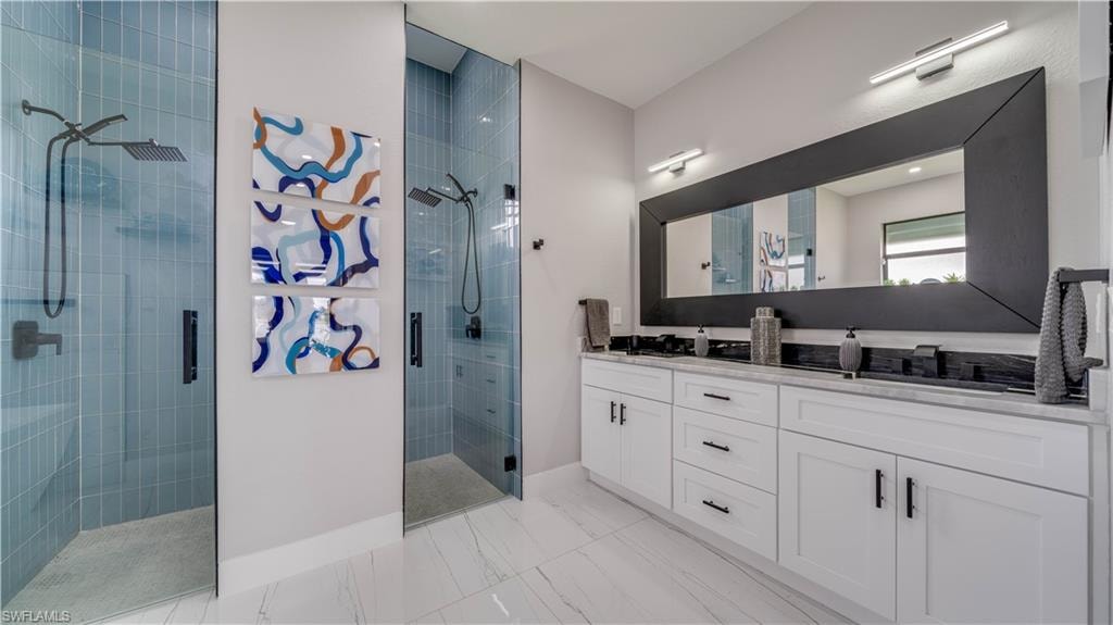 Primary bath double vanity with granite counter and custom wood cabinets