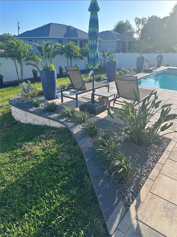 View of swimming pool featuring a fenced backyard and patio surround