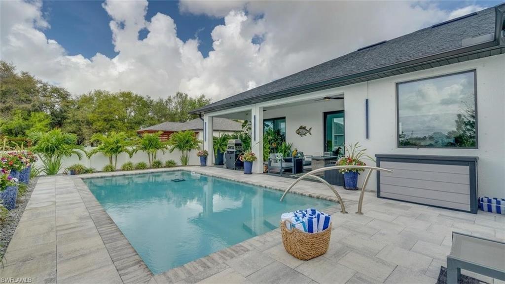 View of swimming pool with open lanai for grilling, relaxing, and entertaining. (Virtually enhanced)