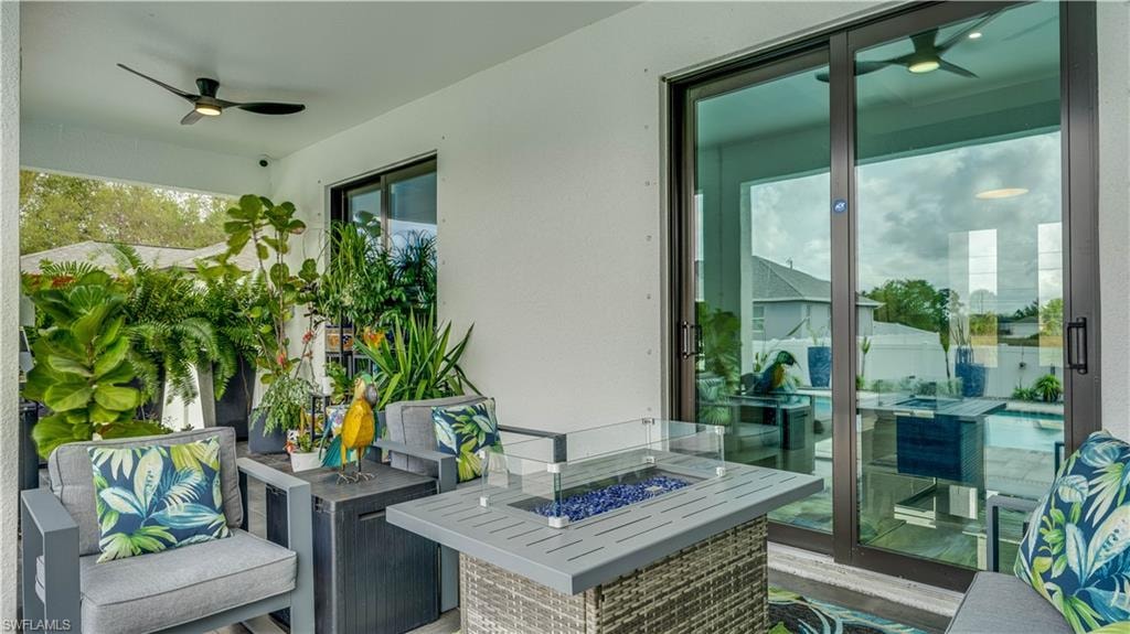View of patio / terrace with ceiling fan and an outdoor living space with a fire pit