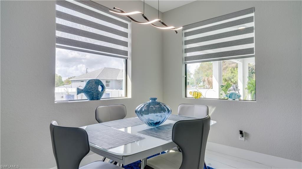 Dining space with picture windows and modern chandelier.