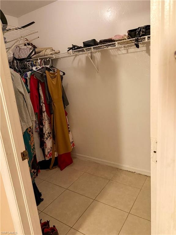 Walk in closet with light tile patterned floors