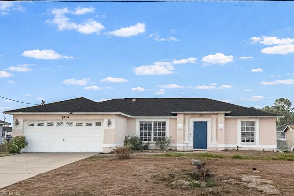 Single story home featuring an attached garage, concrete driveway, and stucco siding