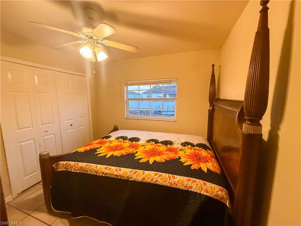 Bedroom with a ceiling fan, a closet, and light tile patterned floors