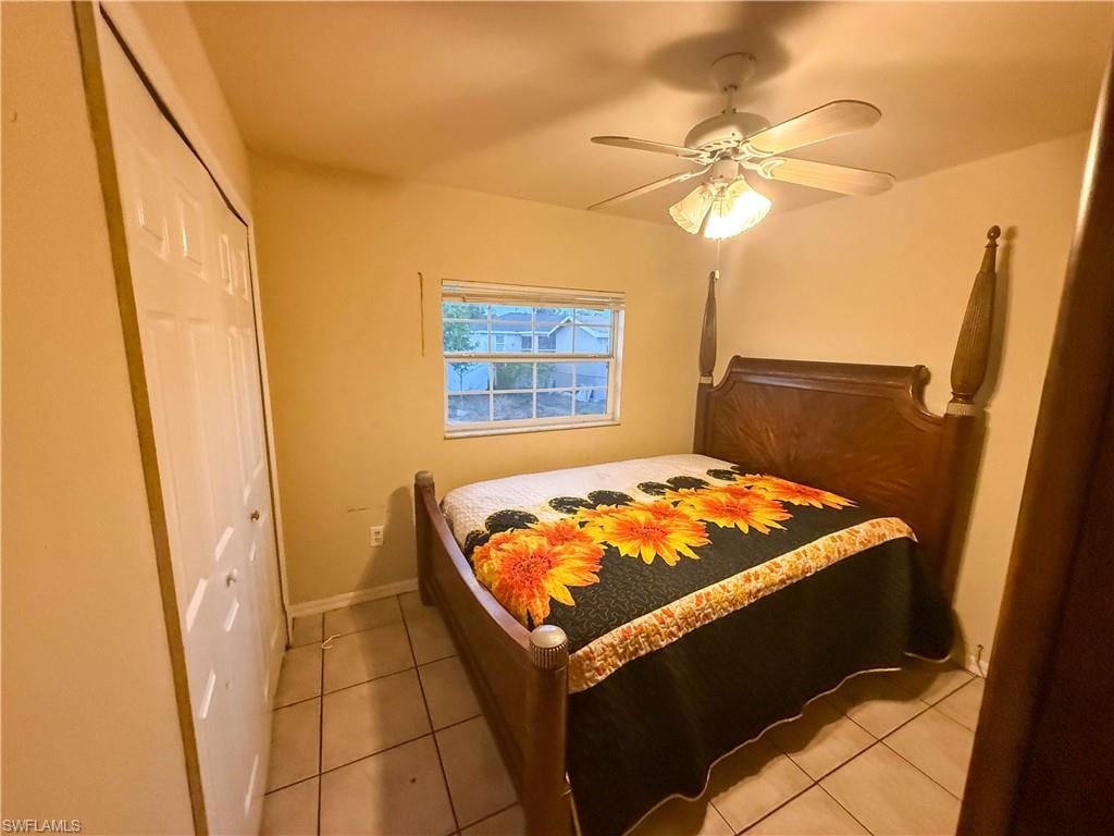 Bedroom with a closet, a ceiling fan, and light tile patterned floors
