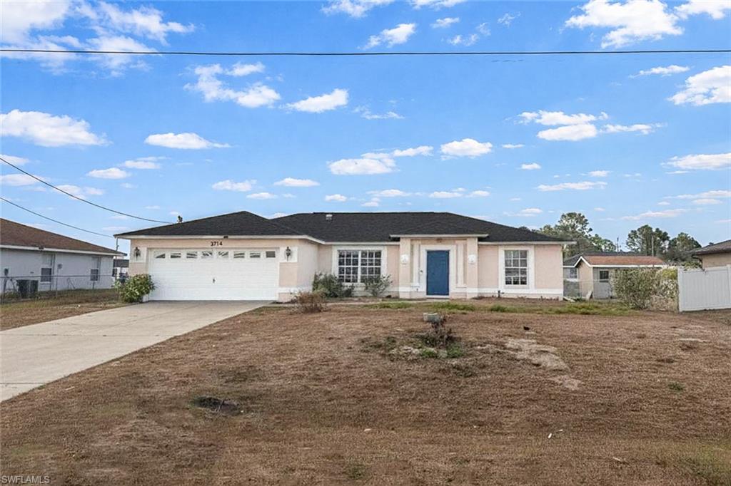 Single story home with concrete driveway, an attached garage, and stucco siding