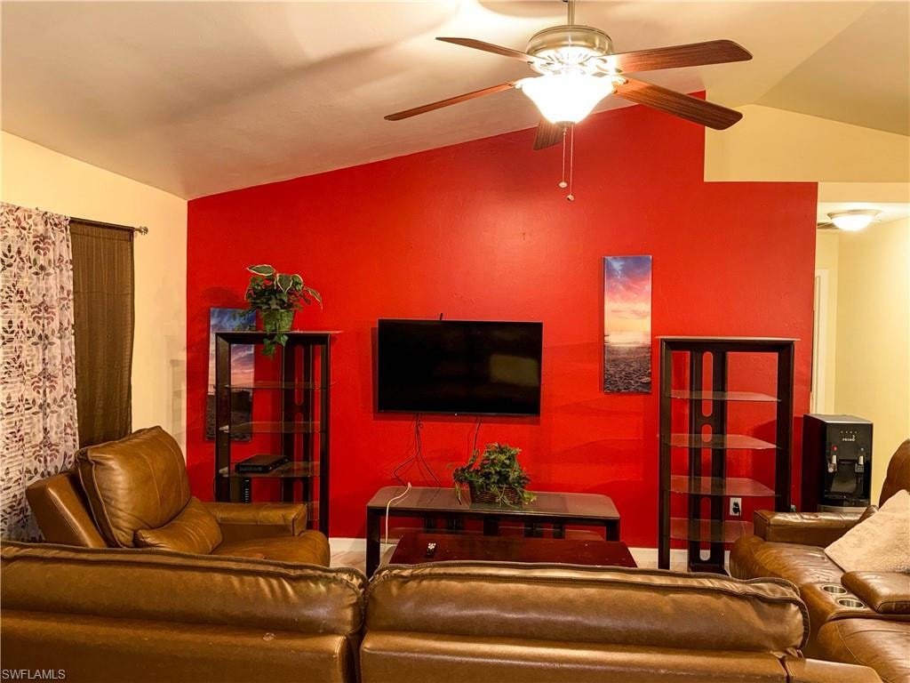 Living area with lofted ceiling and a ceiling fan