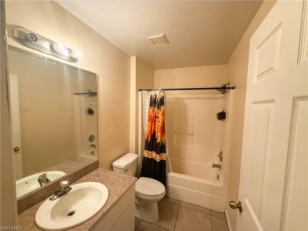 Bathroom featuring vanity, light tile patterned flooring, and shower / bath combo