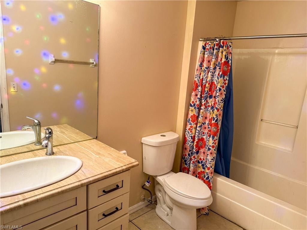 Bathroom featuring vanity, shower / bathtub combination with curtain, and light tile patterned floors