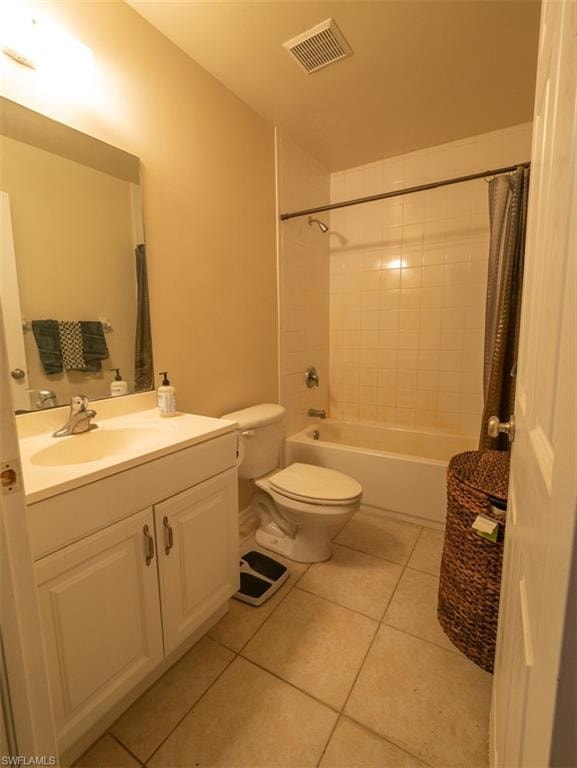 Full bathroom featuring tile patterned floors, vanity, toilet, and shower / tub combo with curtain