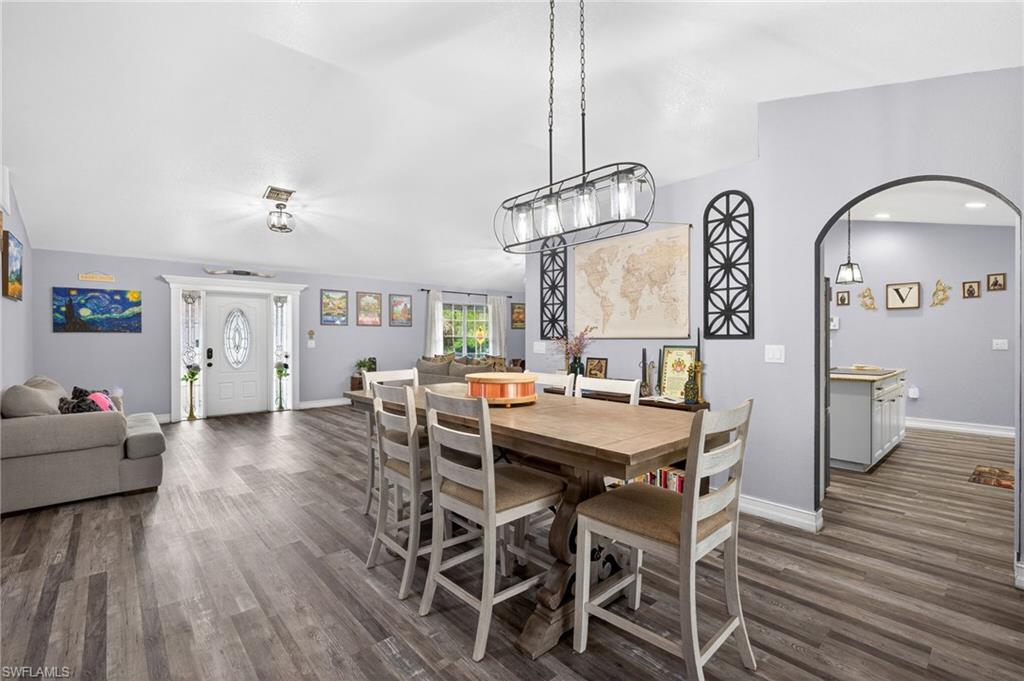 Dining room featuring dark wood-style floors and arched walkways