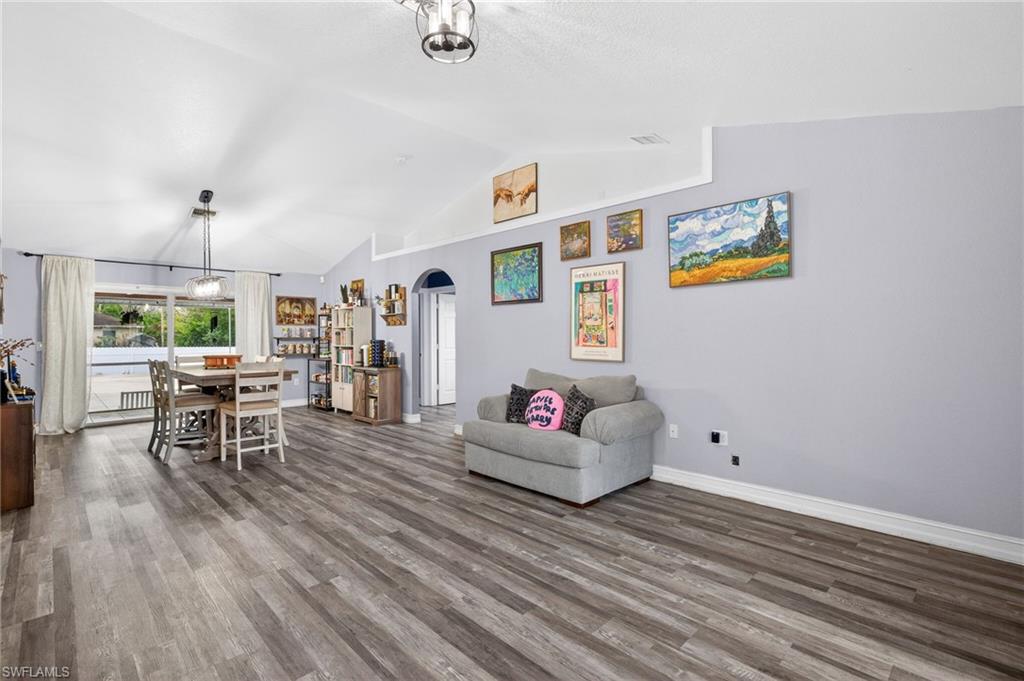 Living area featuring arched walkways and wood finished floors