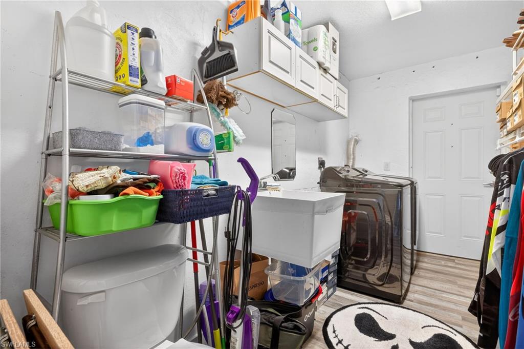 Laundry room featuring cabinet space, washer / clothes dryer, and light wood-style flooring
