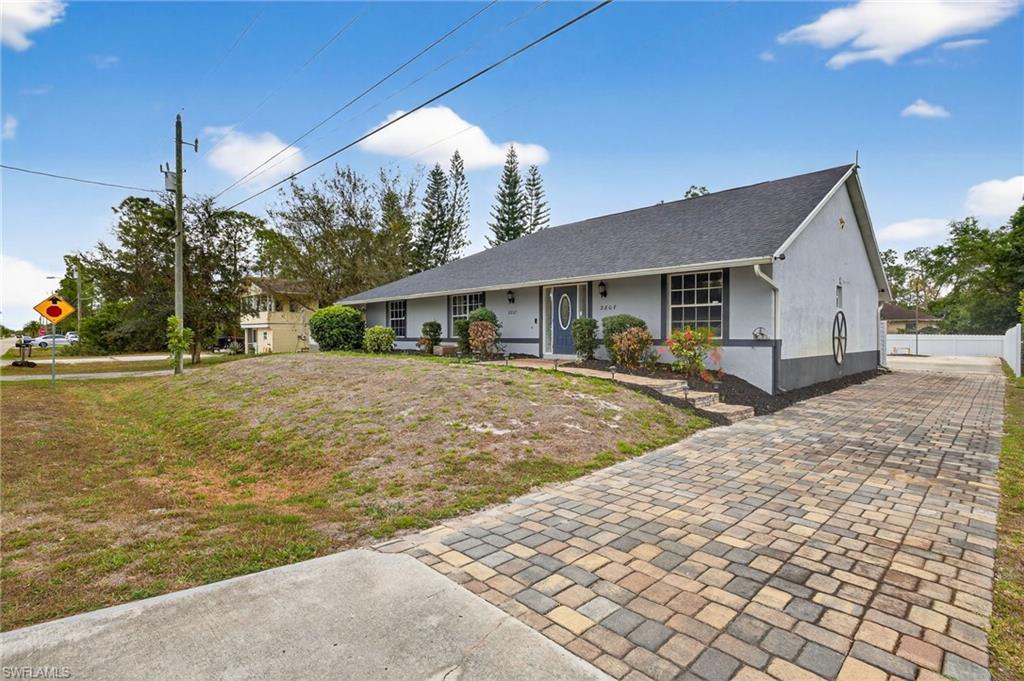 Single story home with decorative driveway, stucco siding, roof with shingles, and a porch