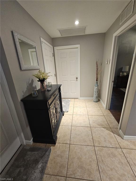 Hall with baseboards and light tile patterned floors