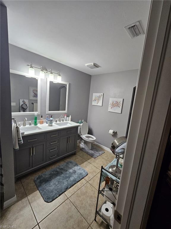 Bathroom featuring double vanity and light tile patterned flooring
