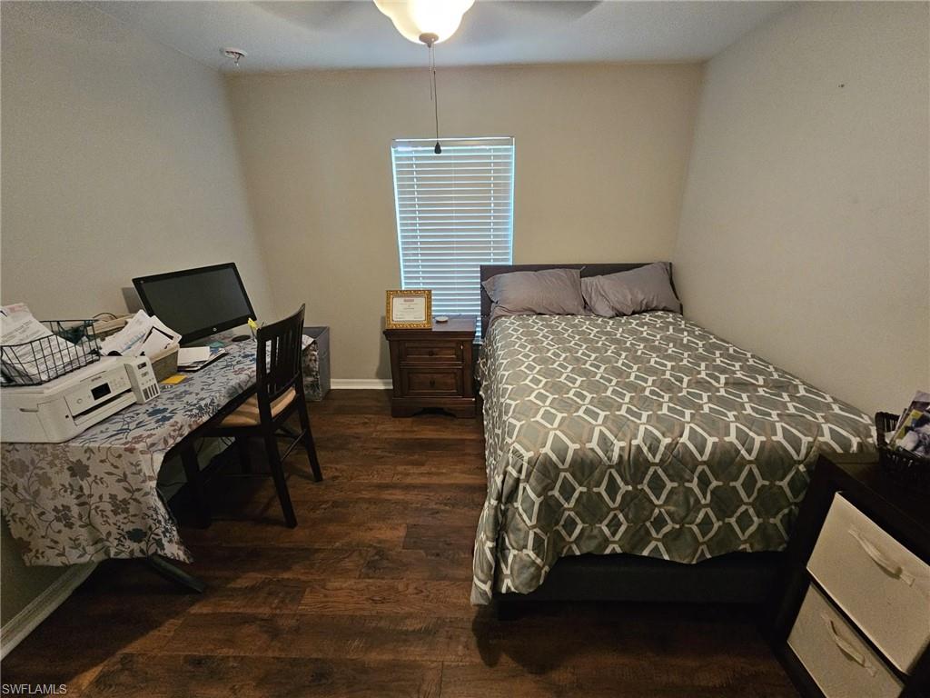 Bedroom featuring dark wood-style flooring, a desk, and ceiling fan
