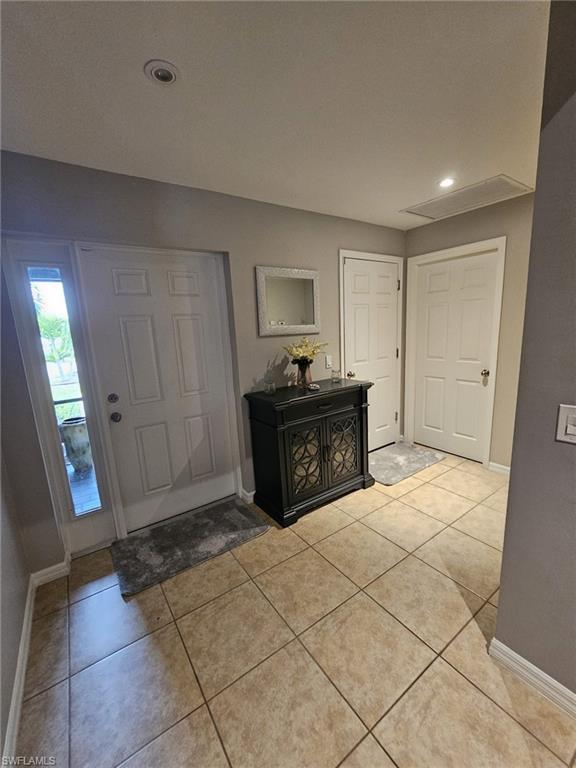 Foyer entrance featuring light tile patterned floors