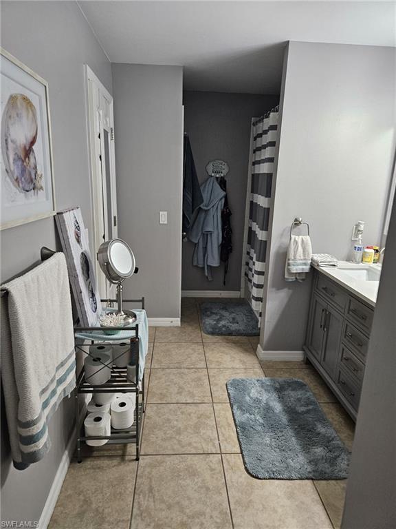 Bathroom with vanity, a shower with curtain, and light tile patterned floors