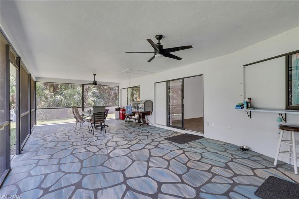 Huge enclosed lanai with a beautiful view of the pool area and lush landscaping. Access to master bedroom and both living areas.