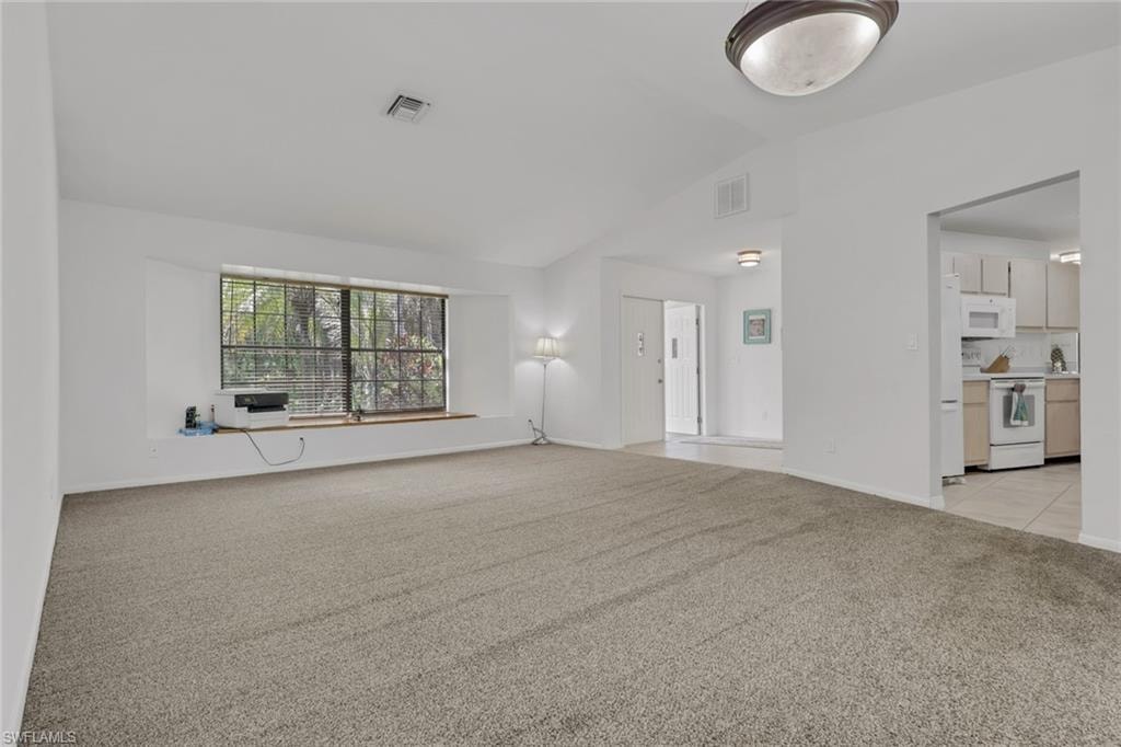 Spacious living and dining area with vaulted ceilings, window seat with storage, access to the kitchen, lanai, tons of natural lighting.