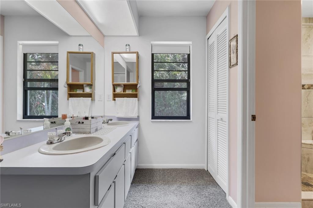 Master bathroom features dual sinks, linen closet, spacious tile shower.