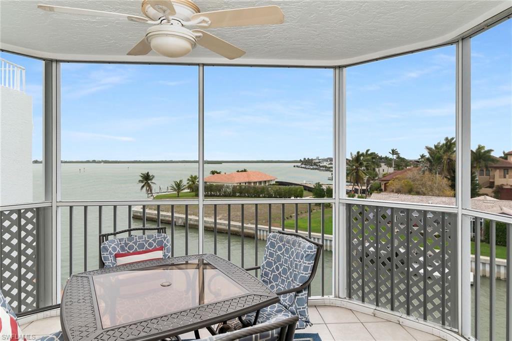 Sunroom / solarium with a water view, floor to ceiling windows, a textured ceiling, tile patterned floors, and plenty of natural light