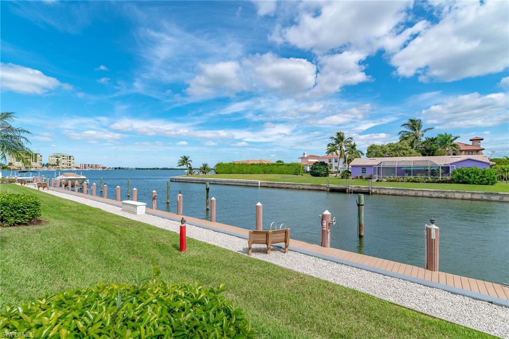 Dock featuring a lawn and a water view