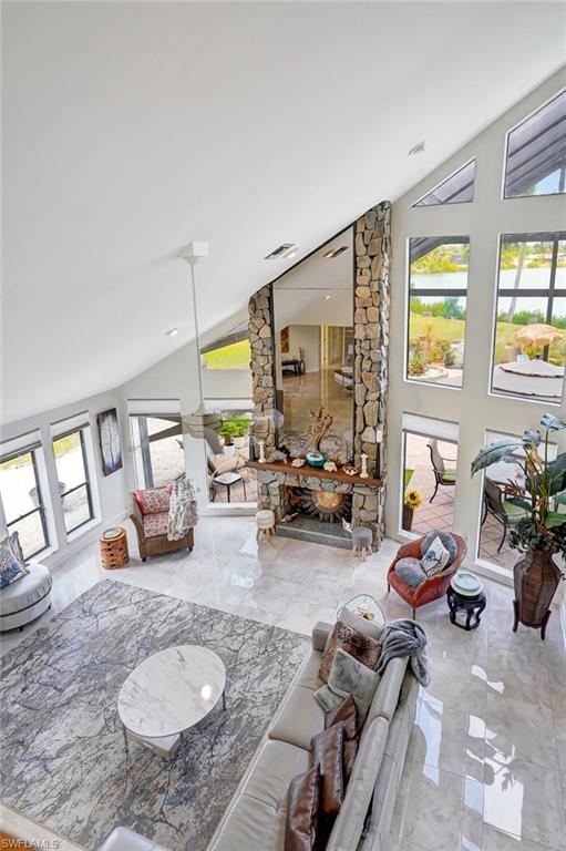 Living area with marble finish floor and vaulted ceiling