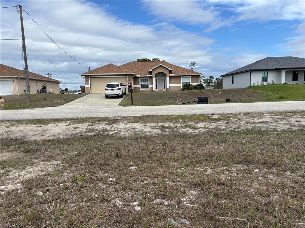 View of yard with concrete driveway and an attached garage