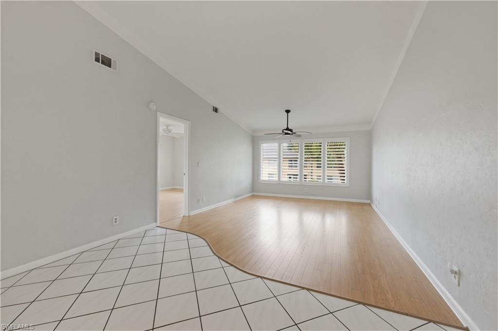 Great room with ornamental molding, light tile patterned floors, and a ceiling fan