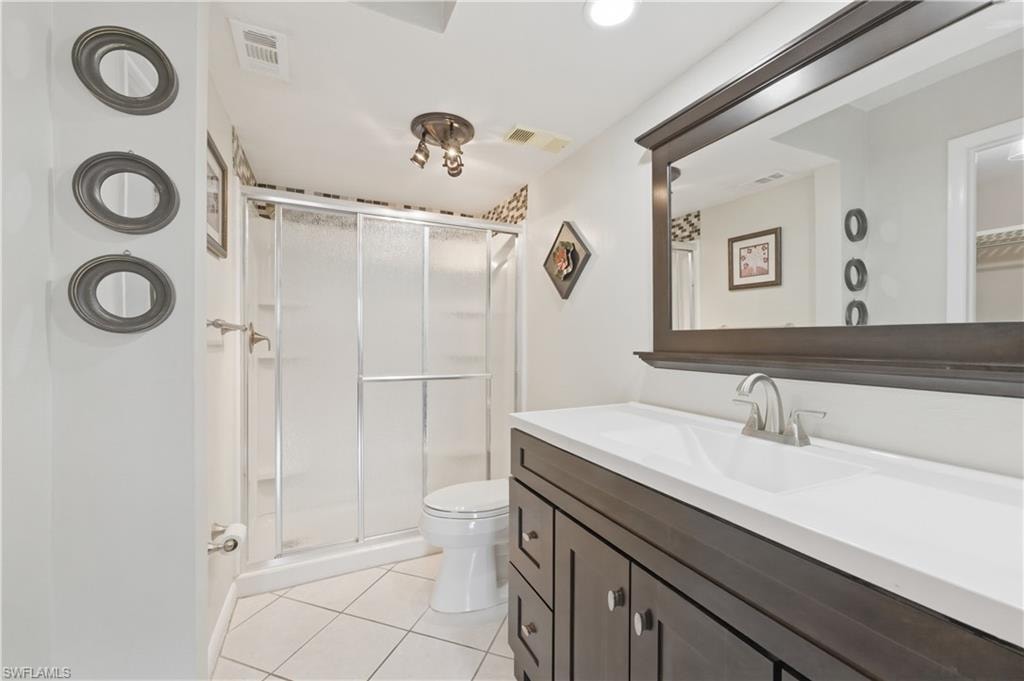Master Bathroom with vanity, light tile patterned floors, and a shower stall