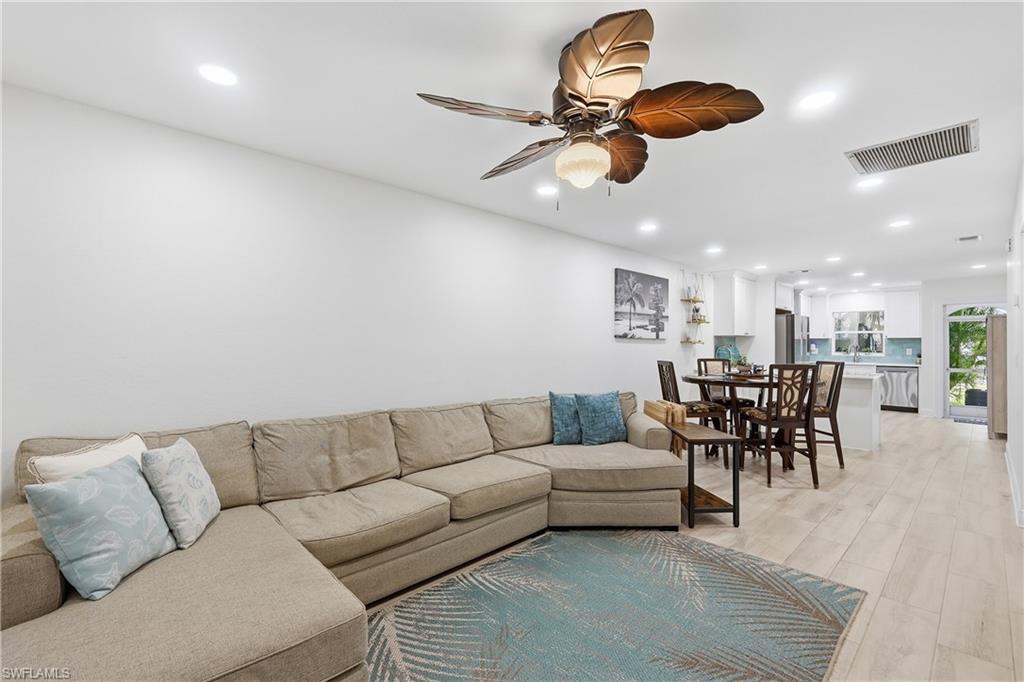 Living room with recessed lighting, ceiling fan, and light wood-type flooring