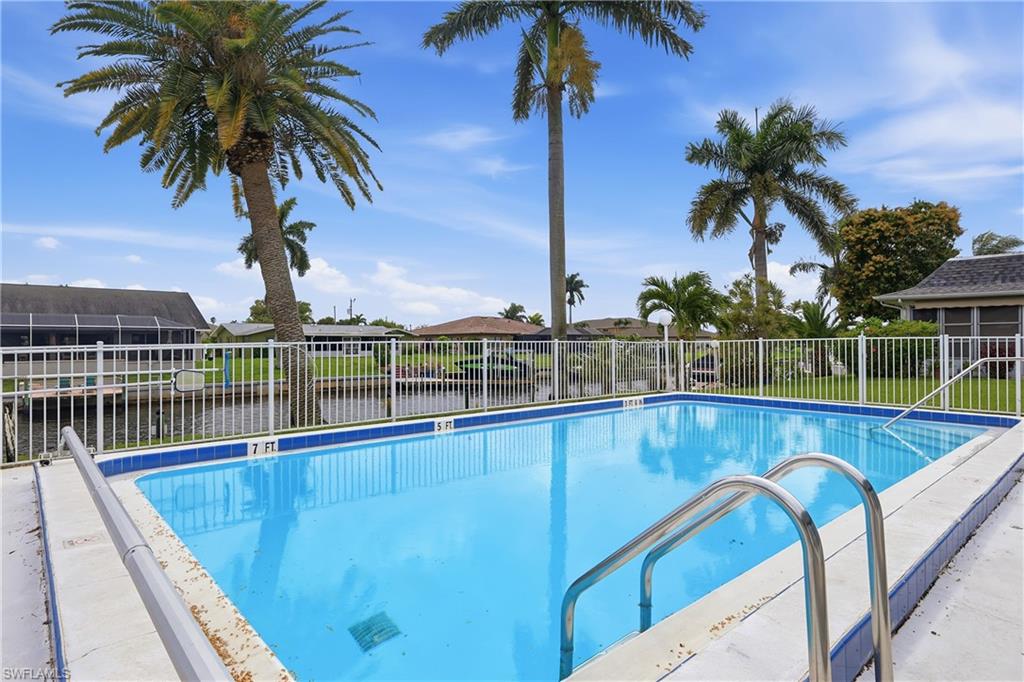 Community pool with a patio and a residential view