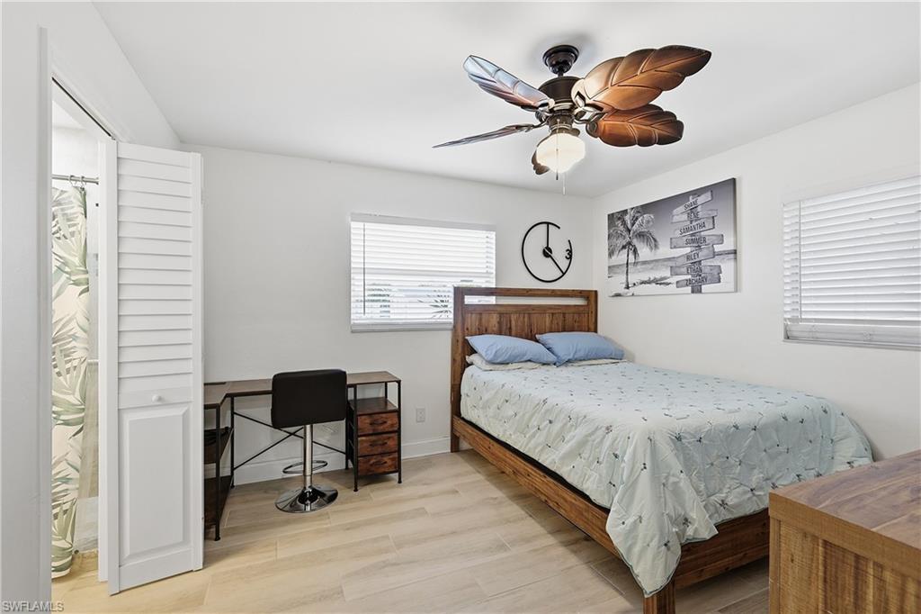 Bedroom featuring light wood-type flooring, a ceiling fan, and a desk