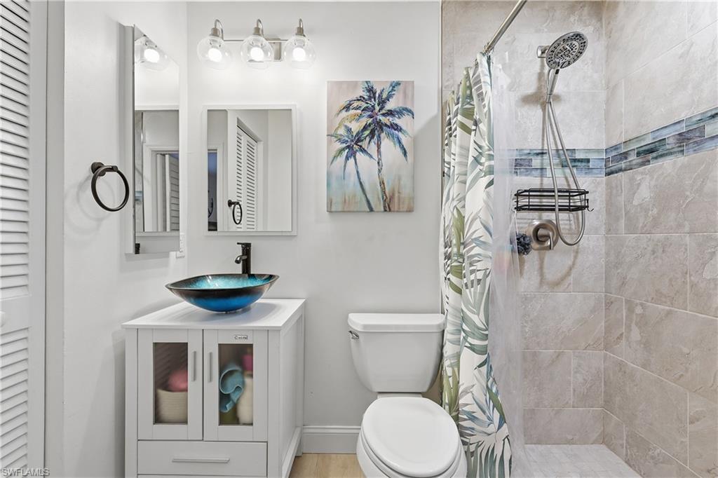 Full bath with a closet, vanity, and a stall shower