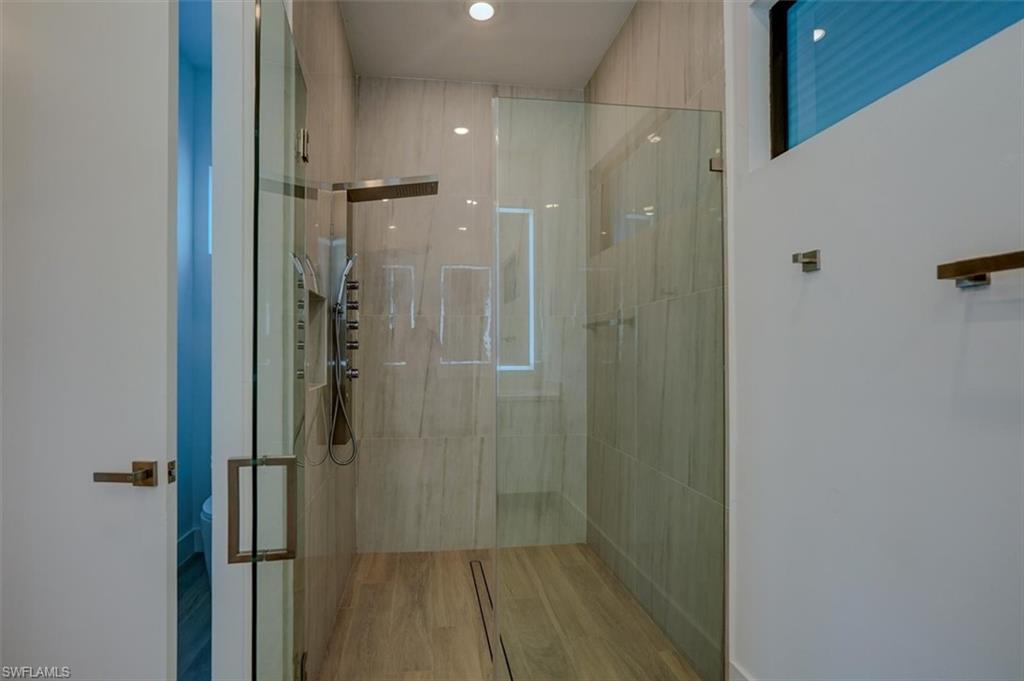 Bathroom featuring hardwood / wood-style floors and an enclosed shower