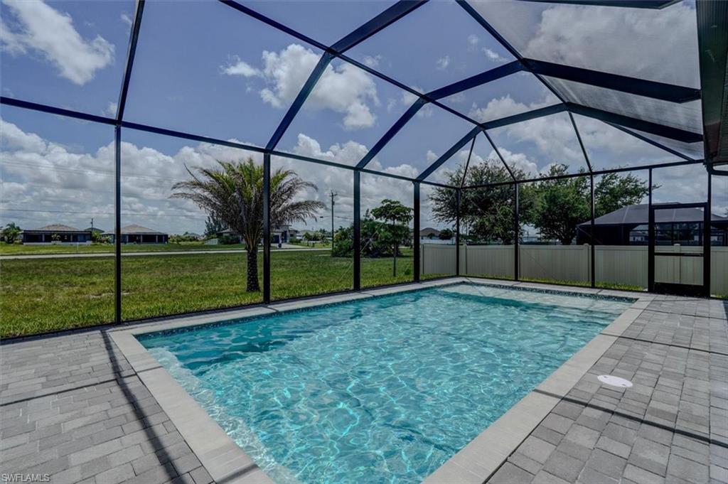 View of pool with a lanai, a patio area, and a lawn