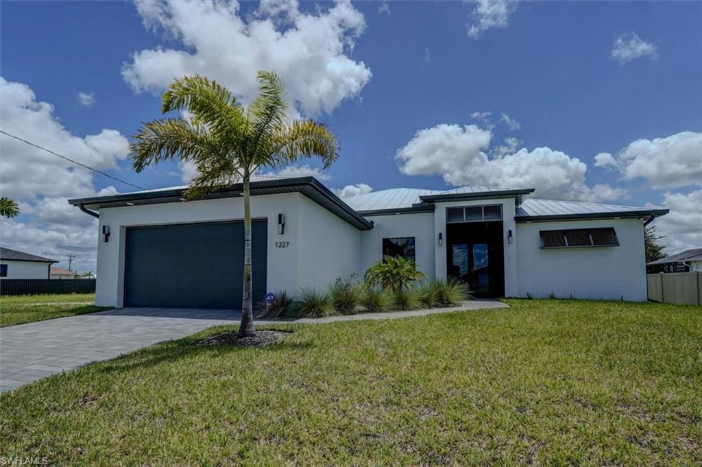 View of front of house featuring a garage and a front lawn
