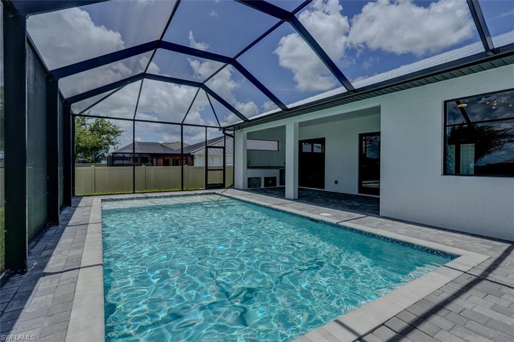 View of swimming pool featuring a patio and glass enclosure