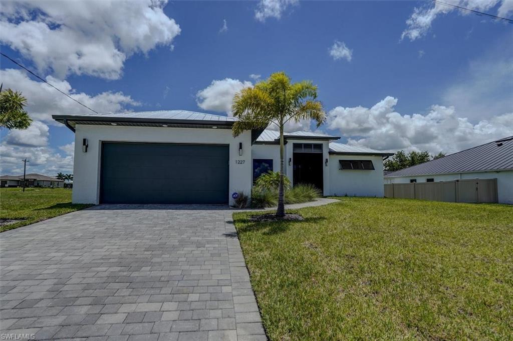 View of front facade featuring a garage and a front yard