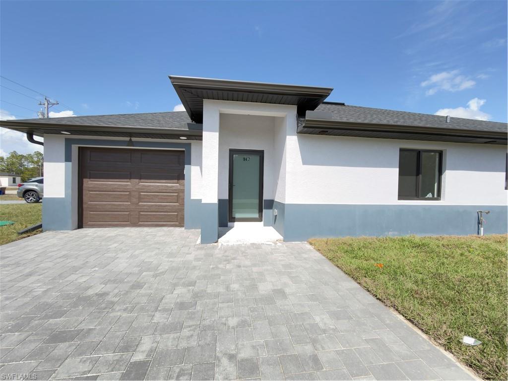 Prairie-style house with a front yard, an attached garage, and stucco siding