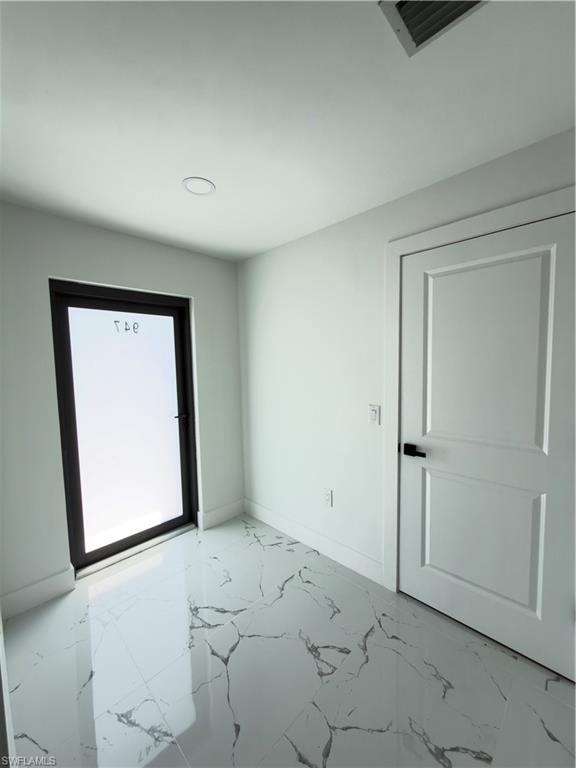 Spare room with light marble finish floors