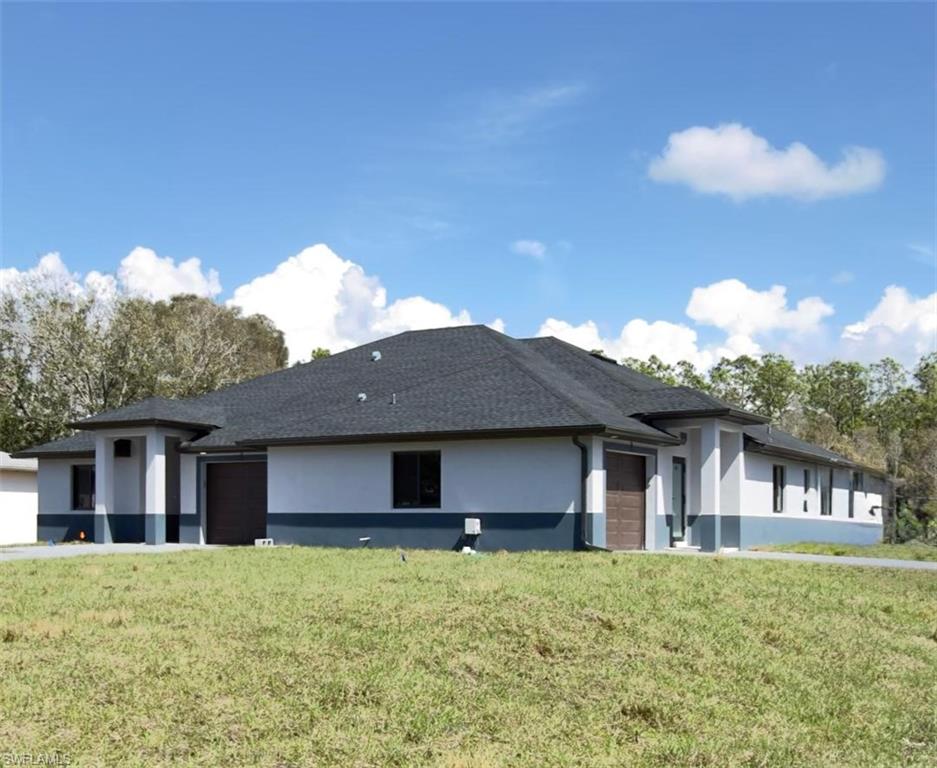 View of front of property featuring stucco siding, a front lawn, an attached garage, and a shingled roof
