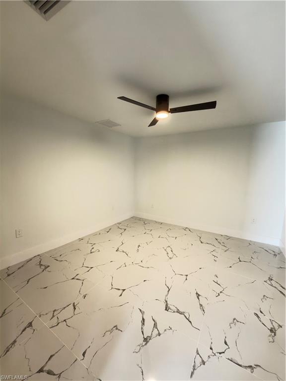 Empty room featuring baseboards and ceiling fan