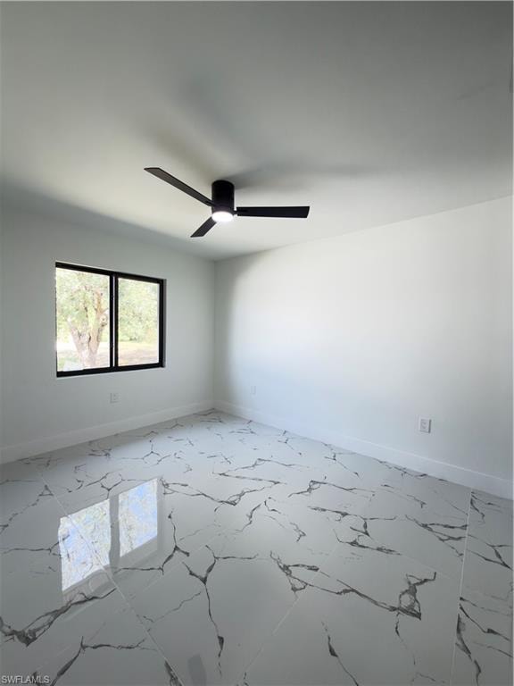 Unfurnished room featuring a ceiling fan and light marble finish flooring